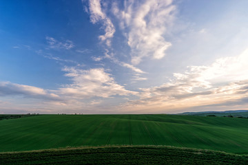 Wall Mural - Scenic view of beautiful country landscape. Clouds passing above rural fields in South Moravia, Czech Republic.