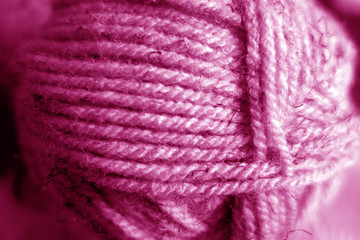 Wall Mural - Yarn ball close-up with blur effect in pink tone.