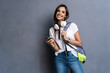 © opolja - Young beautiful woman with smart phone. Smiling student girl going on a travel. Isolated on gray background.