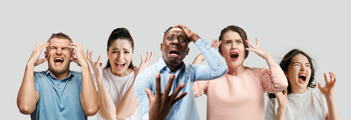 Wall Mural - Horrible, stress, shock. Half-length portrait isolated at white studio background. Young emotional surprised people clasping head in hands. Human emotions, facial expression concept. Creative collage.