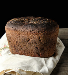 baked rye bread lies flour on a textile towel