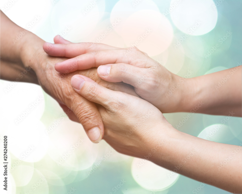 Caregiver, carer hand holding elder hand in hospice care. Philanthropy kindness to disabled concept. - obrazy, fototapety, plakaty 