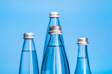 Glass Water Bottles On A Light Blue Background