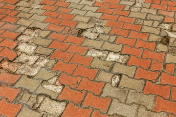 Wall Mural - Street background of old paving stone. Background of old cobblestone pavement close-up. Old paving tiles, green grass growing among them, texture of paving stones and green grass, close-up, top view