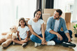 © Peakstock - Pretty family moving home. Couple with child sitting on their new apartment with many carton boxes