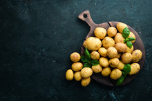 Fresh Potatoes On A Black Background. Organic Food. Top View. Free Space For Text.