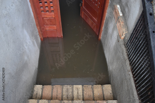 Flooded basement after the massive rain. Flooded cellar with wooden door full of dirty water.