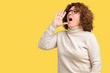 © Krakenimages.com - Beautiful middle ager senior woman wearing turtleneck sweater and glasses over isolated background shouting and screaming loud to side with hand on mouth. Communication concept.