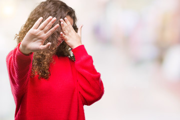 Sticker - Beautiful brunette curly hair young girl wearing glasses and winter sweater over isolated background covering eyes with hands and doing stop gesture with sad and fear expression. Embarrassed