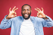 © denis_vermenko - Happy young African-American man isolated against red background. Ok sign.