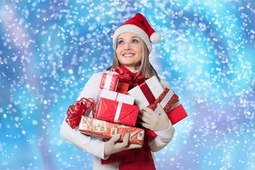 Smiling woman with many gift boxes on background