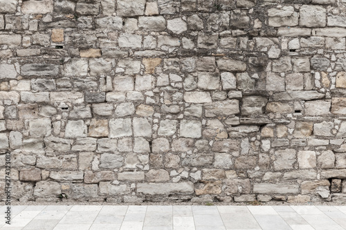 Fotomural Gray rough stone wall and white floor tiling