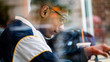 © ezellhphotography - Chicago, IL/United States-June 12th 2019:  Young attractive Middle eastern male model drinks his coffee from behind the window glass at a local Chicago shop.  the student ponders about the day