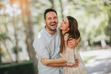 Cheerful young couple having fun and laughing together outdoors