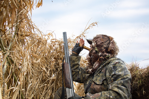 the hunter hides in the reeds and lures the ducks