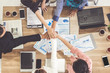© InfiniteFlow - Businessmen and businesswomen joining hands in group meeting at multicultural office room showing teamwork, support and unity in business. Diversity workplace and corporate people working concept.