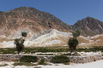 view of the Caldera of the volcano on Nisyros, a huge crater with snow-white sediments, sulfur crystals, from a height, the landscape around resembles a desert