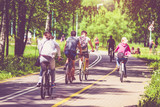 Fototapeta  - Cyclists ride on the bike path in the city Park 