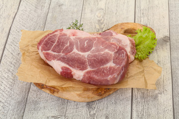 Raw pork steak over wooden board