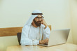 © master1305 - Arab saudi businessman working online with a laptop and tablet in his comfortable cabinet or office. Male model as an enterpreneur. Concept of business, finance, modern technologies, start up, economy