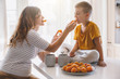 © Alena Ozerova - Pregnant mom with kid eating fruits together in the kitchen