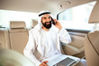 © master1305 - Arab saudi businessman working online with a smartphone, calling his clients or partners in his car. Male model as an enterpreneur. Concept of business, finance, modern technologies, start up, economy