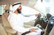 © master1305 - Successful arab saudi businessman riding his car or driving full of emotions at sunny day. Male model as an enterpreneur. Concept of business, finance, modern technologies, start up, economy.