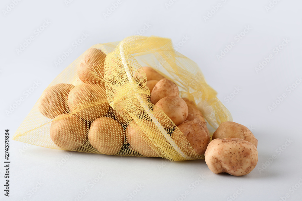 Eco bag with potato on light background