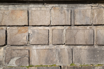 A wall of rectangular cement blocks on a Sunny day. Backgrounds texture design.