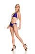 © Jasmina - Pretty young lady in blue swimsuit and sandals on white background