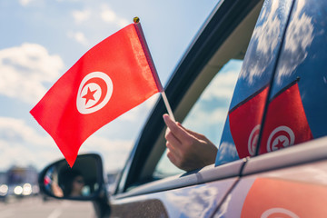 Wall Mural - Woman or Girl Holding Tunisia Flag from the open car window