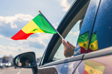 Wall Mural - Woman or Girl Holding Senegal Flag from the open car window