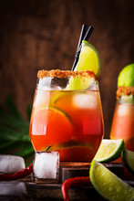 Michelada - Mexican Alcoholic Cocktail With Beer, Lime Juice, Tomato Juice, Spicy Sauce And Spices, Vintage Wooden Background, Selective Focus
