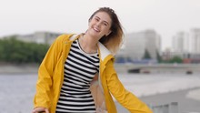 Pretty Young Girl In Yellow Rain Coat Joyfully Walking In A City In Good Mood