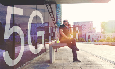 Young businessman using a smartphone with the new 5G mobile network. Urban scene in the street and empty copy space for Editor's text.