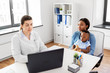 © Syda Productions - medicine, healthcare and pediatry concept - african american mother with baby son and caucasian doctor with laptop computer at clinic