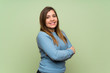© luismolinero - Young girl over green wall with arms crossed and looking forward