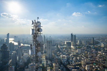 Telecommunication tower with 5G cellular network antenna on city background