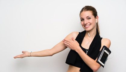 Wall Mural - Young sport woman over isolated white background extending hands to the side for inviting to come