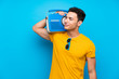 © luismolinero - Handsome man over blue background holding a radio