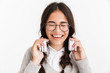 Photo closeup of joyous teenage girl wearing eyeglasses laughing while listening to music with headphones