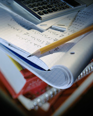 Selective focus image of school homework with notebook open to hand written math formulas