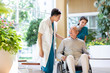 © Blue Jean Images - Young doctor talking with patient in nursing home