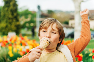 Wall Mural - Happy kid boy eating stracciatella ice cream in spring park