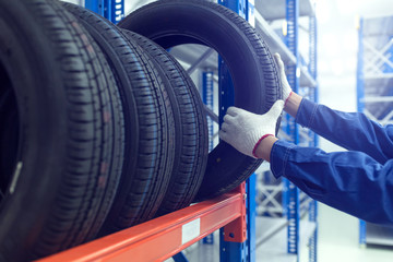 Large modern warehouse with forklifts and stack of car tires