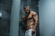 © sutulastock - Sexy muscular man with naked torso in shower. Bodybuilder. Mature content