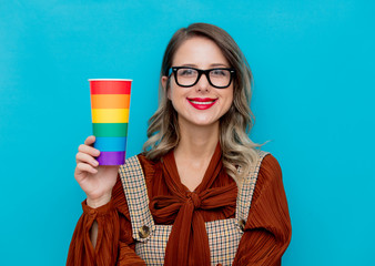 Wall Mural - Young woman holding a cup with rainbow colors