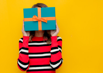 Wall Mural - Young woman in red striped sweater with gift box