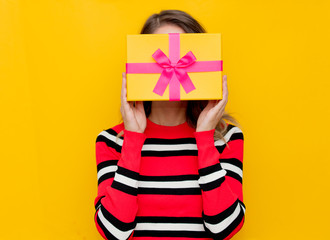 Wall Mural - Young woman in red striped sweater with gift box