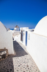 beautiful Oia town on Santorini island, Greece. Traditional white architecture and greek orthodox churches with blue domes over the Caldera, Aegean sea. Scenic travel background